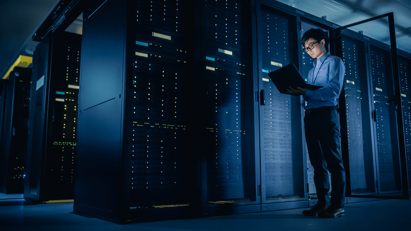 man holding laptop standing in control room