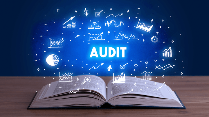 the word "audit" in blue hovering over a book