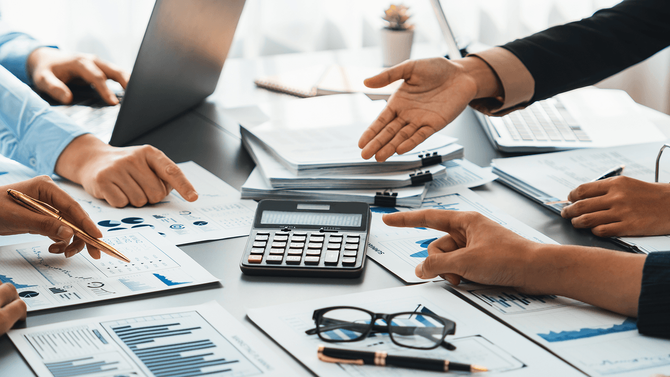 suited hands around a calculator on a table