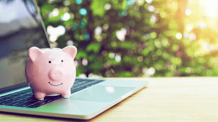 piggy bank sitting on laptop